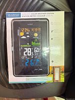 Front of retail box showing weather station display and features