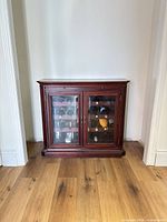 Front view of mahogany cherry wine cabinet with glass doors showing interior wine racks