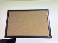 Front view of one Quartet cork bulletin board showing cork surface and black plastic frame