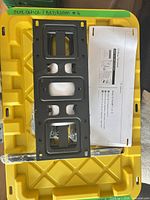 Front view of wall plate, hardware bag, template and arms on yellow tote