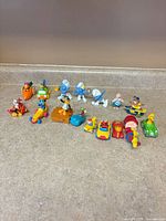 Full group of 16 assorted small plastic toys lined on countertop