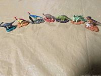All seven metal dinosaur figures in a row