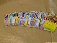 Fanned display of 30 sleeved Pokémon cards on surface