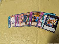Front view of spread showing various Yu-Gi-Oh! cards with different border colours