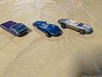 All three redline Hot Wheels cars side by side