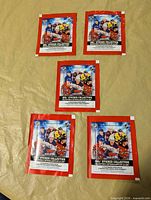 Front view of five sealed Topps 2023-24 NHL Sticker Collection packs