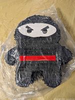 Full view of sealed black character pinata