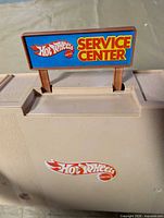 Closed beige plastic case with Hot Wheels Service Center sign