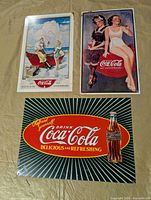 All three Coke metal signs laid out together