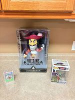 Group shot: Captain Hook plush box centered, Funko Pop and Bicycle cards to sides