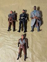 Four Dune figures laid out on surface