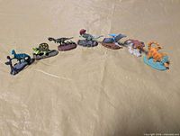 All eight painted metal dinosaur miniatures lined in a row