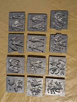 Overview of all 12 metal dies laid out in four rows of three