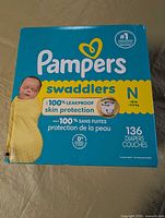 Front view of sealed Pampers Swaddlers box showing size N and 136 diapers count.