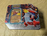 Front view of sealed Skeledirge-ex tin showing promo card through window