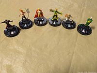 All six WizKids HeroClix miniatures lined up on combat dials