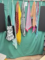 All scarves and tote bag hanging on backdrop