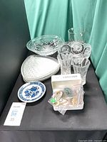 All glass pieces, Delft plate and earring box arranged on tabletop