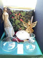 Full lot view showing both angels, two decanters, casserole dish and holly pillow