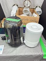 Honeywell humidifier, Asakuki humidifier and box of ceiling fan parts grouped on table