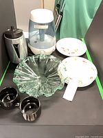 Group shot of all seven items: humidifier, percolator, glass bowl, two floral plates, two black mugs
