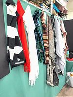Row of assorted acrylic knit scarves hanging on display, showing variety of colours, patterns and TekSavvy branded piece