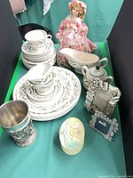 Overall lot showing dinnerware stacks, gravy boat, sugar bowl, pewter cup, photo frame, doll, trinket box