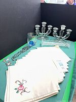 group shot showing napkins, jewellery, tumbler, dish, candelabra