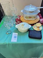 Overall lot showing casseroles, board, glasses, cup, bracelet, pouch