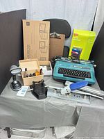Full lot showing all office items including typewriter, lamp, stapler, hole punch, clipboard, file folder box, file frame box and supplies tray
