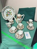 Full view of entire porcelain tea and espresso set arranged on surface