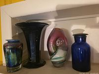 Four vases side by side on shelf