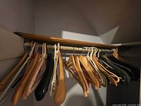 Closet rod with mixed wooden, plastic and braided fabric hangers