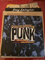 Front cover of book partially inside envelope with visible clippings