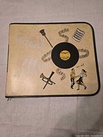 Front view of beige zippered binder showing graphics and overall condition