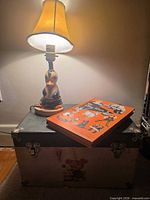 Lamp, book and trunk together for scale and context