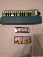 Melodica, case, harmonica, instruction packet displayed