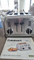 Front view of stainless steel Cuisinart 4-slice toaster with instruction booklet