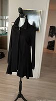 Full view of black A-line coat on mannequin