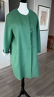 Full front view of green MaxMara coat on mannequin