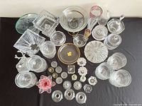 Overview of approximately 40 assorted glass and crystal pieces laid out