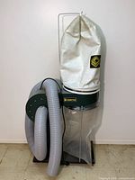Full view of Craftex dust collector with hose and bags