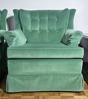 Front view showing tufted back, seat cushion, skirted base