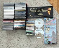 All CDs, cassette tapes, Andrew Lloyd Webber box, sealed Christmas set, loose discs arranged on carpet