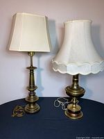 Pair of brass table lamps with shades on tabletop