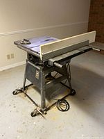 Rockwell 34050 table saw on wheeled stand with rip fence attached