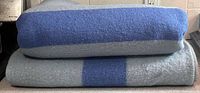 Two folded blankets stacked, showing colour and thickness