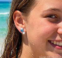 Model wearing one blue enamel silver-tone dolphin stud earring