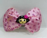 Front view of pink glitter heart bow hair clip showing central cartoon girl embellishment