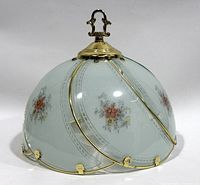 Front three-quarter view showing frosted green glass, floral panels and brass finial